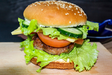 hamburger on a wooden tray on a dark background