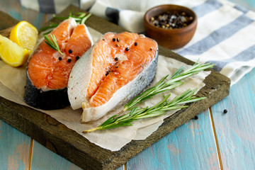 Fresh organic fish. Salmon steaks on a wooden cutting board with spices. Copy space
