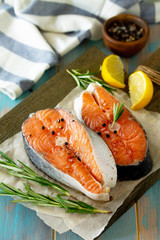 Fresh organic fish. Salmon steaks on a wooden cutting board with spices.