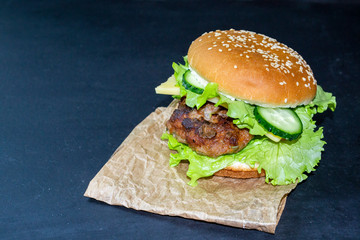hamburger on a wooden tray on a dark background