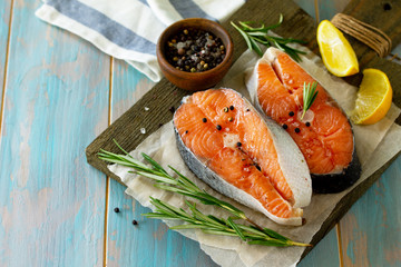 Fresh organic fish. Salmon steaks on a wooden cutting board with spices. Copy space