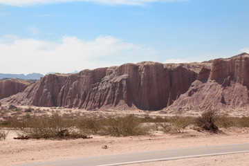 A road crosses the red rocks of La Quebrada de las Conchas, Argentina
