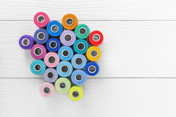 Colored threads on spools on a white background,
