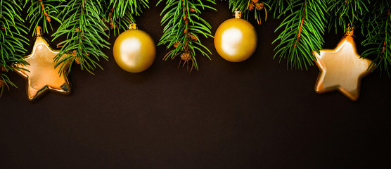 Christmas background with festive decoration. Branches of coniferous trees with gold decorations. Merry Christmas and Happy New Year. Flat lay, copy space for your text.