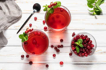 Fresh vitamin tea with cranberry and mint on white rustic table top view. natural drinks for healthy lifestyle. Traditional autumn and winter tea.