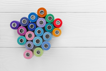 Colored threads on spools on a white background,