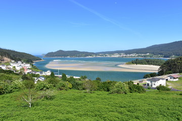 Fototapeta premium Bay with small fishing village and coastal river. O Barqueiro, A Coruña Province, Spain.