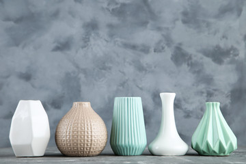 Different ceramic vases on grey background