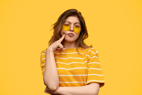 Stylish young woman poking cheek