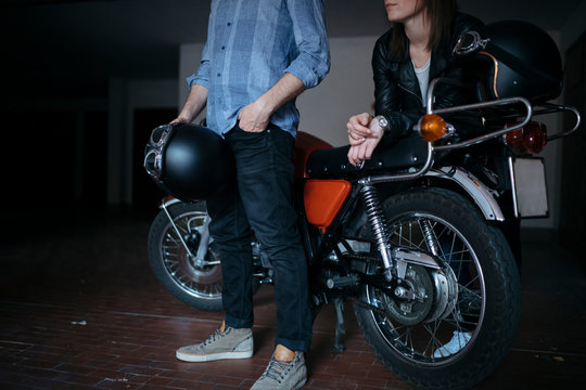 Couple with vintage motorbike parked in garage