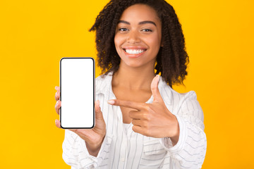 African american millennial woman showing blank cellphone screen