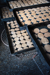 galletas en bandejas rectangulares negras sobre canastos de metal vacíos en panadería 