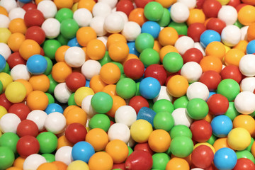Fototapeta na wymiar Close-up view of multi-colored handmade caramel balls of different colors: white, green, blue, red, orange and yellow. Colorful and tasty background.