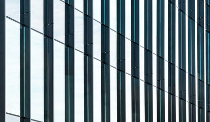 Glass facade texture of a modern office building. High tech architecture. Elements of urban design. Reflections in the windows.