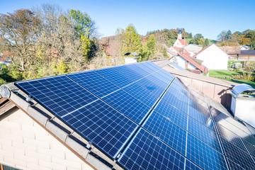 Solar panels and sunlight reflextions on the roof against blue sky background. Concept clean power...