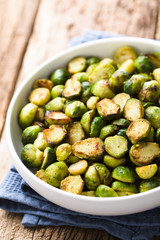 Fresh homemade roasted Brussels sprouts in white bowl (Selective Focus, Focus one third into the bowl)