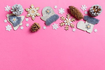 Top view of holiday toys and decorations on pink Christmas background. New Year time concept with copy space