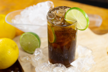 Fototapeta na wymiar Rum and Cola Cuba Libre with Lemon and Ice