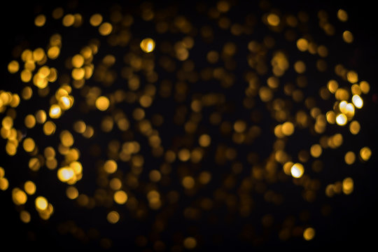 little gold stars on black background Festive holiday background. Celebration concept. Top view, defocused, blured