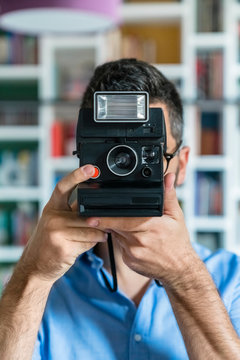 Young man taking photo with instant camera