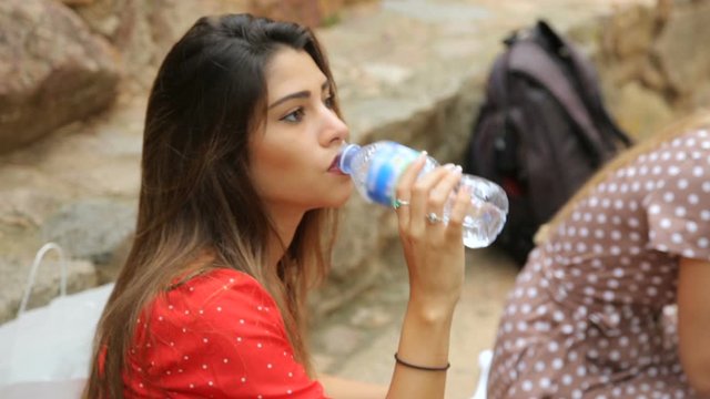 Woman drinking water from plastic bottle