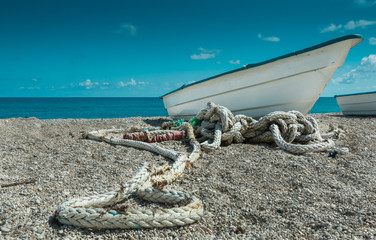 Fototapeta premium dramatic angle of fishing rope and boat on the caribbean coast in a small village