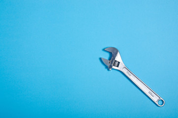 adjustable wrench work tool on blue background, plumbing work, top view