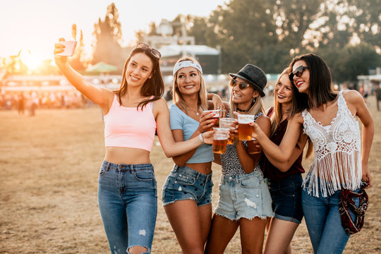 Female friends having fun and taking selfie at music festival