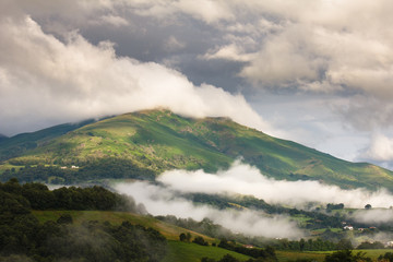 Mountain landscape, green valley. Clouds floating over the tops of the mountains in the French...