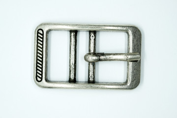 Square nickel-plated buckle with a flat tongue on a white background. Chrome metal fittings hardware for the manufacture of belts.