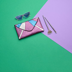 Fashion party girl Flat lay. Minimal. Woman Essentials accessories, cosmetic makeup. Trendy Clutch, sunglasses, brushes. Coloful purple mint Set. Creative pop art geometry concept, vibrant color
