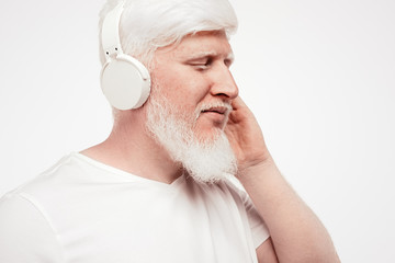Fototapeta premium Man with albinism listening to music through headphones