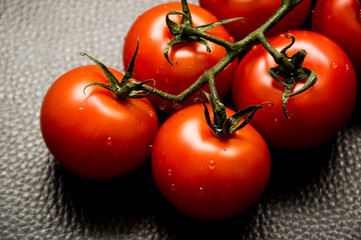 fresh tomatoes with water drops on black background