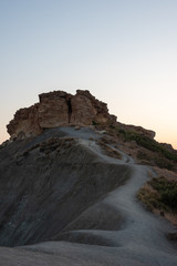 Path leading to a big rock on the hill. Sunset at Ghajn Tuffieha, Malta. 