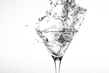 Black-white glass with champagne splashes on a white background
