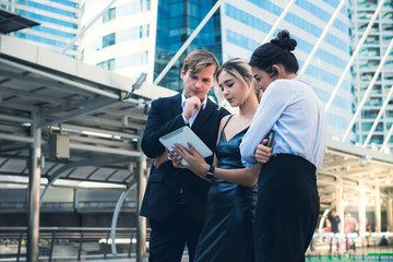 A team of business men and women Looking at the result data from the genuine tablet, to help think and analyze to improve the plan, to business and finance concept.