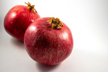 The whole pomegranate and juicy seeds from the pomegranate on the white and dark backround 