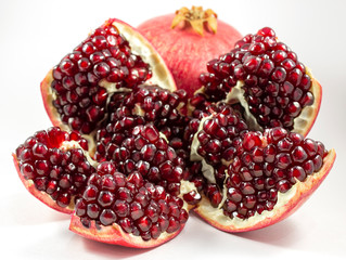 The whole pomegranate and juicy seeds from the pomegranate on the white and dark backround 