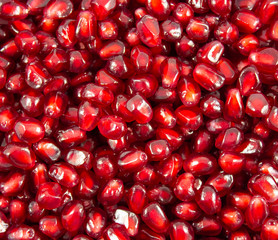 The whole pomegranate and juicy seeds from the pomegranate on the white and dark backround 