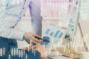 Fototapeta premium Double exposure of chart with businessman typing on computer in office on background. Concept of hard work.