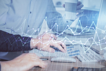 Multi exposure of chart with man typing on computer in office on background. Concept of hard work.