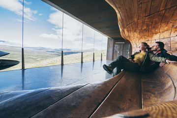 Couple enjoying the view over mountains in Snohetta viewpoint in Norway