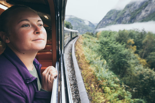 Woman enjoying a ride and looking out the window on Flamsbana mountain railway in Flam, Norway