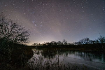 Lake and stars at night, starry sky with Orion