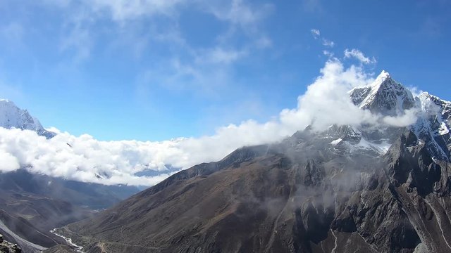 Mount Taboche and Mount Cholatse in the Himalayas, view from Nangartsang peak. Climbers at the top, Nepals flags fluttering in the wind, beautiful day with clouds, view of the valley of souls Himalaya