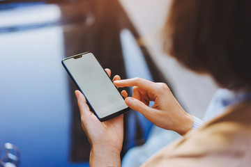 Business woman using blank application on smartphone device. Close up view, texting message in social network