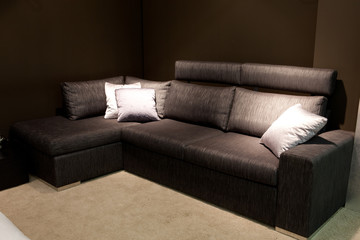 Modern sofa with pillows in a dark room