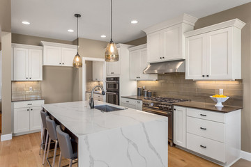 Beautiful kitchen in new luxury home with waterfall island, quartz counter tops, farmhouse sink,...