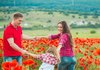 Woman her husband and their daughter in poppy field