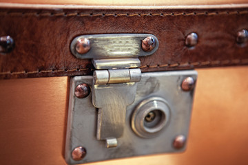 close-up fragment of locks and fasteners on the vintage leather suitcase brown